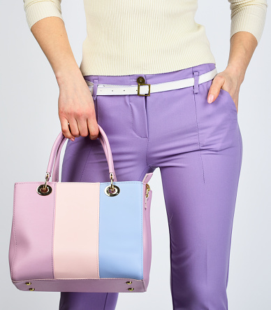 try something different. shopping and business. girl with flight clutch. wear elegant style. fashion model hold leather bag. woman in purple pants. businesslady in stylish outfit.