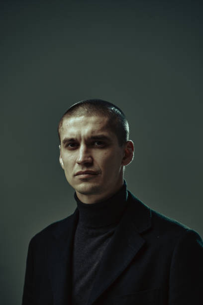 istock Serious handsome confident guy, security or businessman on gray background, studio male portrait with copy space 1299327866