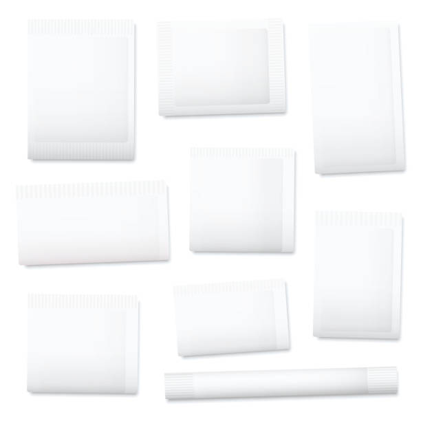 istock White paper sachets, unlabeled blank packaging templates for sugar, salt, tea, seeds, cosmetics, spices, powder, food ingredients etc. Isolated vector illustration on white background. 1299327949