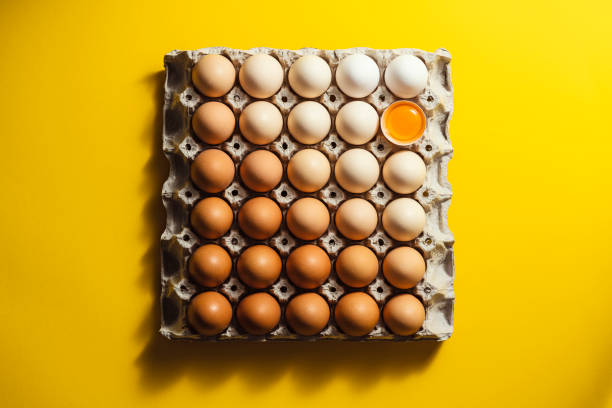 Box of eggs on yellow background