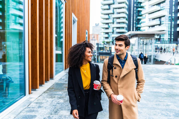 istock Two colleagues are walking around the city and chat 1299330524