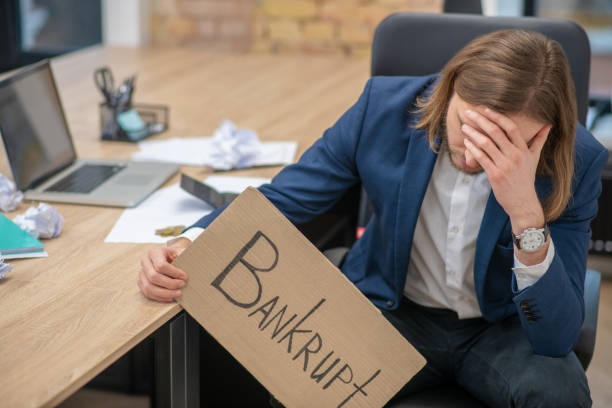 istock Young upset man with bankrupt poster 1299331439