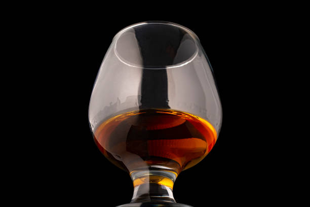 istock Glass of cognac close up isolated on black background. 1299333899