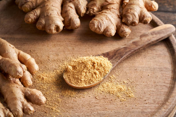 istock Ground ginger on a spoon with fresh ginger root in the background 1299336609