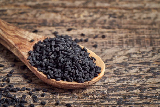 istock Black cumin seeds on a wooden spoon 1299336889
