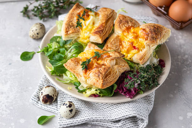 istock Puff pastry mini quiche, pie or tart with vegetables served on a plate with green mix salad. 1299338021