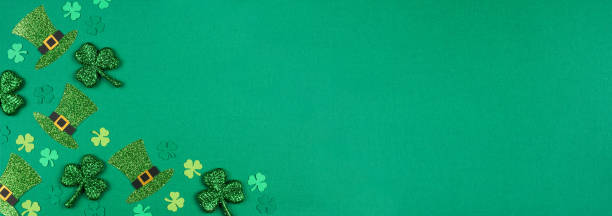 St Patricks Day shamrock and leprechaun hat corner border over a green banner background St Patricks Day shamrock and leprechaun hat corner border. Overhead view on a green paper banner background with copy space. st. patricks day photos stock pictures, royalty-free photos & images