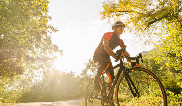 istock Senior triathlete cycling in nature 1299341408