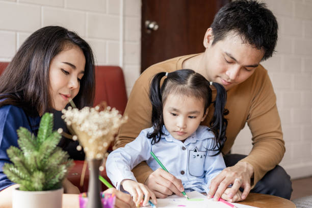 istock Asian parents teaching child how to draw at home 1299341655