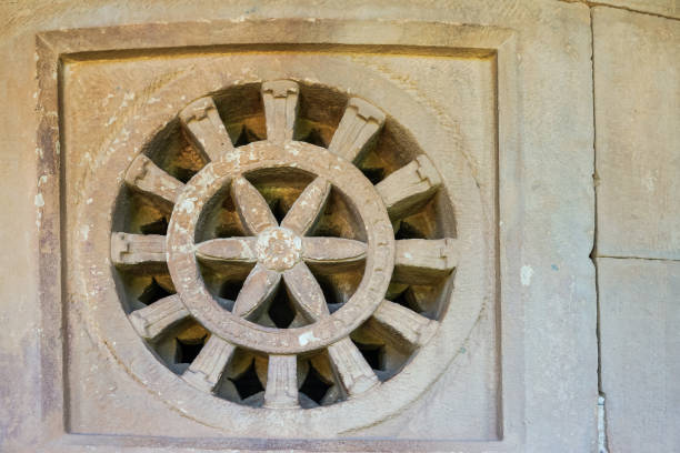 Aihole, Karnataka, India - November 7, 2013: Durga Gudi or Temple. Gray stone window screen showing wheel and big star or flower figure.