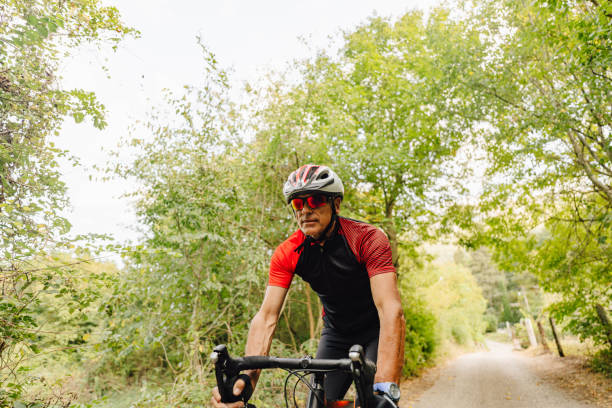 istock Senior triathlete cycling in nature 1299342778