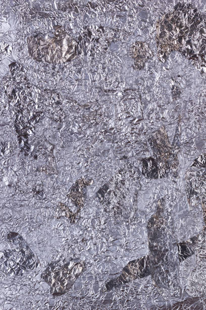 istock Shiny heavily wrinkled metal silver gray foil vertical texture background 1299342871