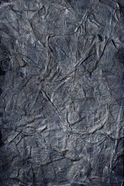 istock Textured handmade dark textile background with mesh and paper base, in black-and-white color 1299342877