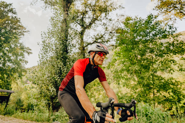 istock Senior triathlete cycling in nature 1299342958
