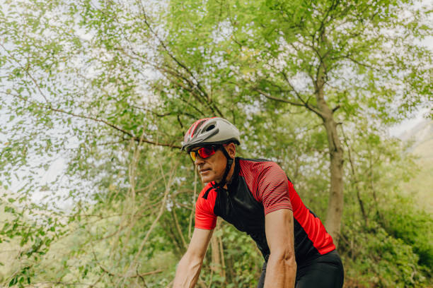 istock Senior triathlete cycling in nature 1299342976