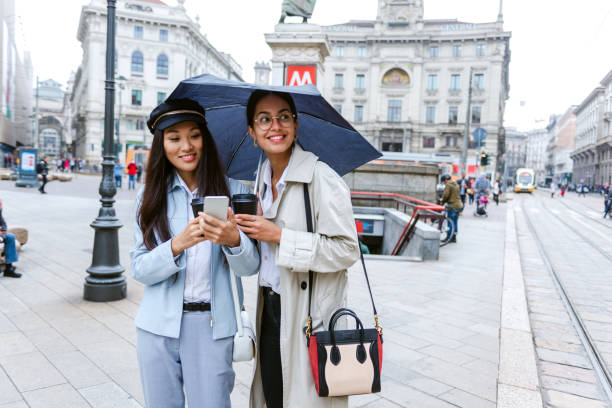istock Two female friends under an umbrella explore the city 1299345233
