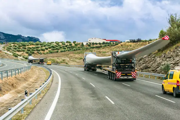 Several special transport trucks on the road transporting wind turbine blades.