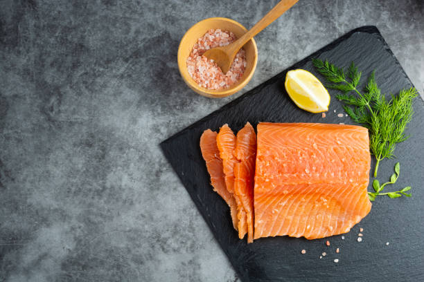 istock Fresh salmon fillet in a plate, top view. gray background. Copy space 1299347106