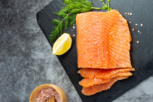 istock Fresh salmon fillet in a plate, top view. gray background. Copy space 1299347153