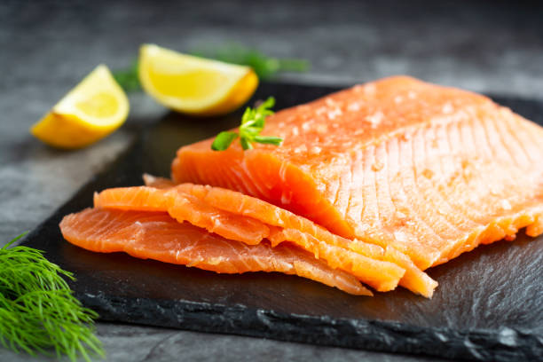 istock Fresh salmon fillet in a plate, top view. gray background. 1299347188