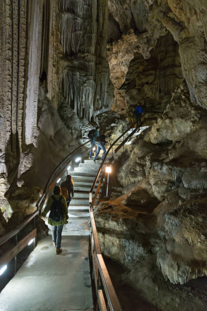 Tourists exploring the limestone caves "Cueva de Nerja" in Spain Nerja, Costa del Sol, Andalusia, Spain, april 21st 2014, the limestone caves "Cueva de Nerja" were discovered in 1959 and hold the world's largest stalactite (33 metres) - nowadays the caves are one of the most popular tourist attractions in Spain (photography without flashlight is permitted inside the caves) nerja caves stock pictures, royalty-free photos & images