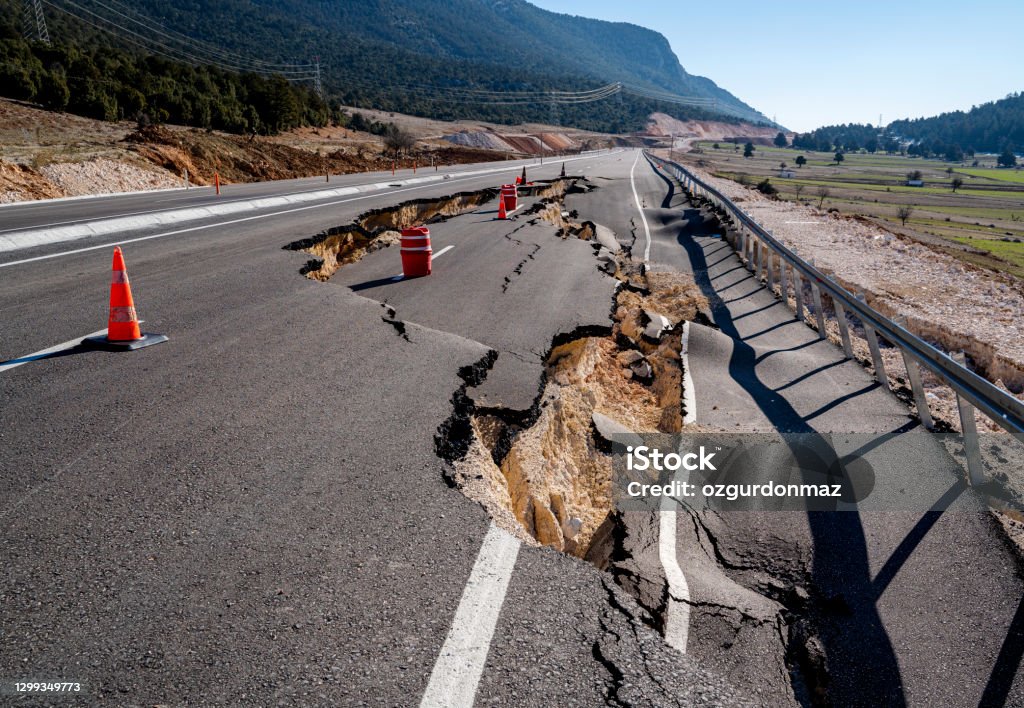 Asphalt road collapsed and cracks in the roadside Earthquake Stock Photo