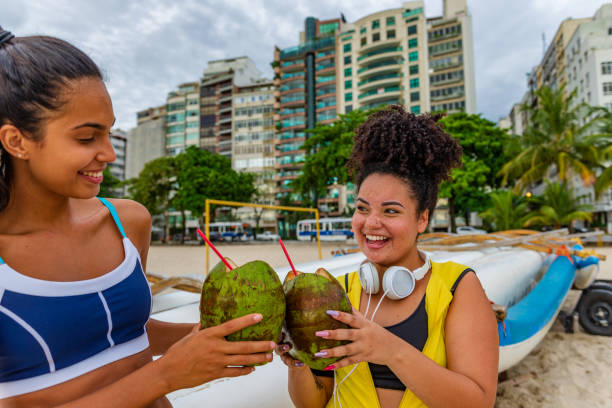 istock Female friends resting on the beach after training 1299353175