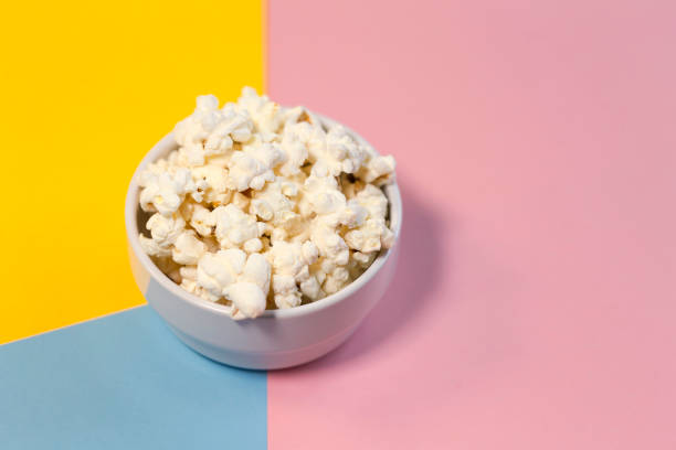 istock Bowl of popcorn on a yellow, pink and blue background 1299353364