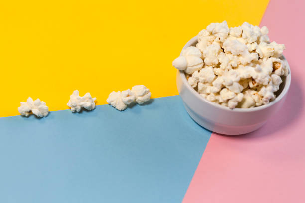 istock Popcorn bowl on yellow, pink and blue background, popcorn road 1299353366