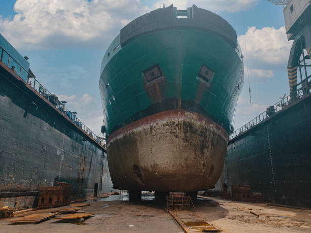istock Industry view - Ocean Vessel in the dry dock in shipyard. Old rusty ship under repair 1299356453