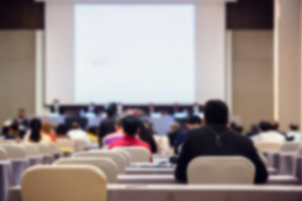 istock Blurry of auditorium for shareholders' meeting or seminar event with projector, 1299358007