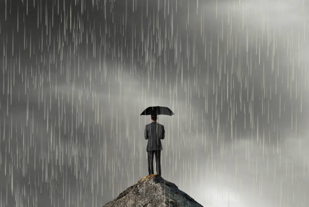 istock Businessman Holding Umbrella Standing On Mountain Top 1299358877