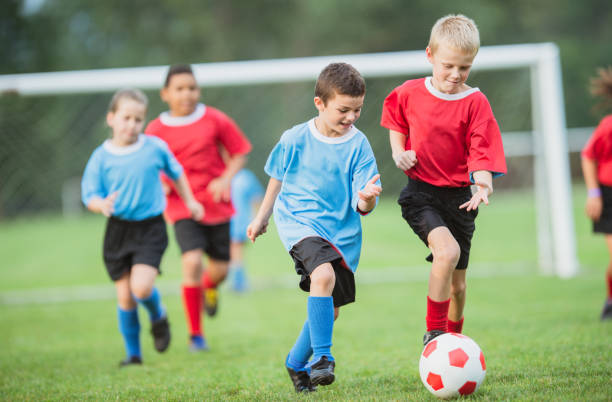 istock Boy playing soccer on the field 1299359757