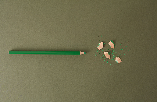 Top View Of Colorful Shavings Of Green Pencil Over Green Background