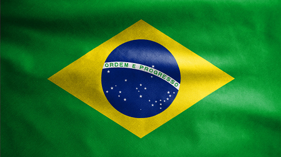Brazilian flag waving in the wind. Close up of Brazil banner blowing, soft and smooth silk. Cloth fabric texture ensign background. Use it for national day and country occasions concept.