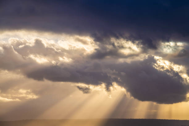 istock A dramatic sunset through the clouds over the ocean with rays of light 1299366312