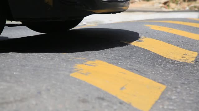 vehicles are seen passing by a speed bump