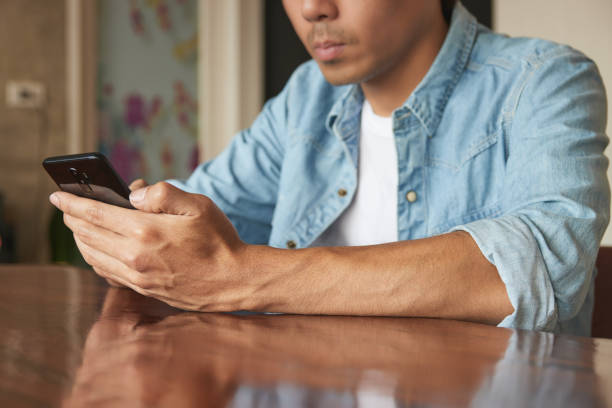 istock Front Left Young Asian Casual Businessman Using Smartphone 1299377992