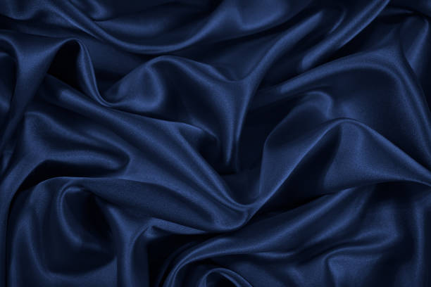 istock Dark blue silk satin fabric. Elegant fabric background. Liquid wave or silk soft wavy folds. 1299381039