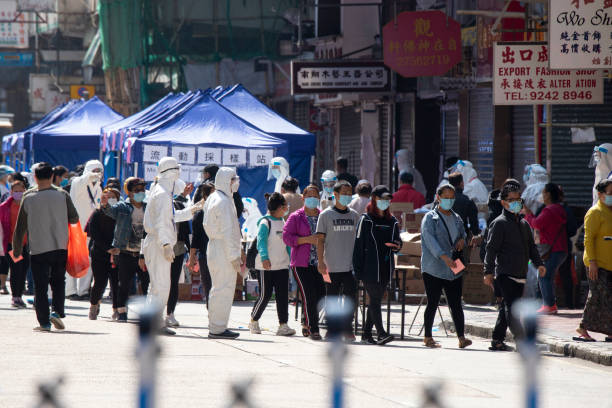neighborhood residents wait in line for a mandatory covid-19 test after locking down of jordan district. - china covid imagens e fotografias de stock