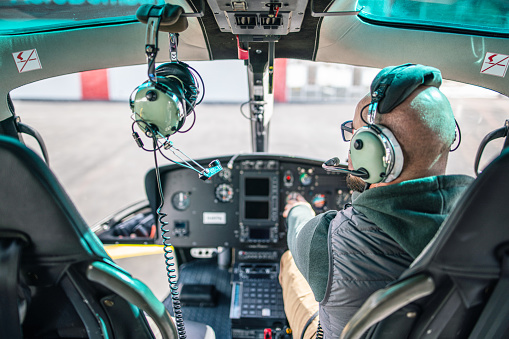 Pilot inside a helicopter cockpit. Preflight check.