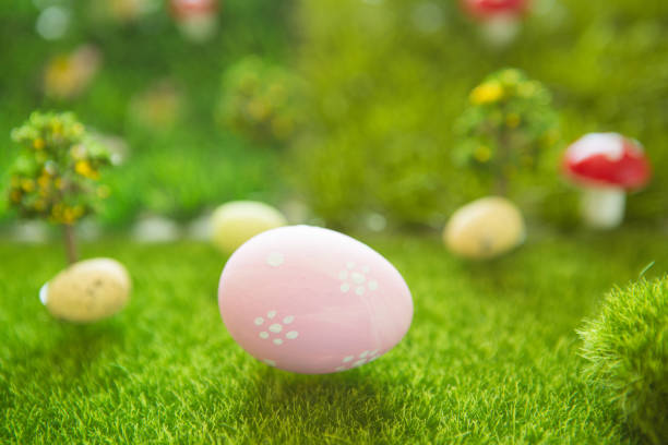 istock Little Easter bunny toys and Easter eggs on green grass. Fairy tale 1299386529
