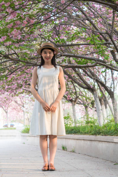 istock beautiful girl and cherry blossom 1299390105