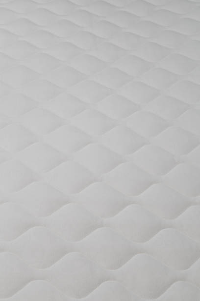 istock Soft white mattress close-up background with selective focus. 1299391726