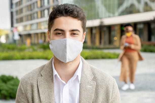 istock Businessman in mask outdoors 1299394676