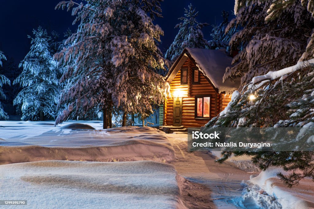 Rustic log house, snow-covered pine trees, big snowdrifts, fabulous winter night Rustic log house, snow-covered pine trees, big snowdrifts, fabulous winter night. Rural beautiful winter landscape. Non-urban scene. New Year, Christmas. Copy space. Christmas Stock Photo