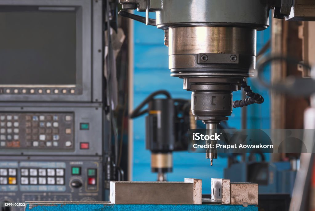 Close up of CNC milling machine tool with mill in chuck preparing to process metal detail in manufacturing workshop area CNC Machine Stock Photo