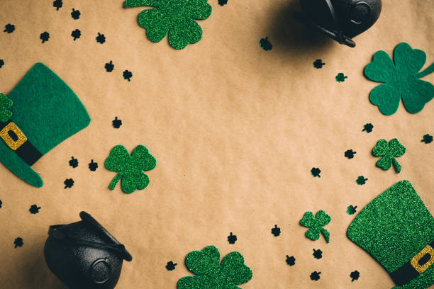 istock Happy Saint Patrick's Day concept. Flatlay composition with green leprechauns hats, shamrock clover leaves on kraft paper background. Flat lay, top view. Vintage, retro style. 1299403392