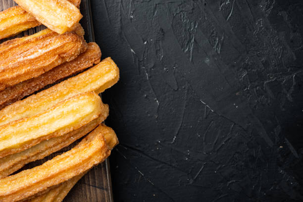 istock Churros with chocolate Traditional Spanish cusine, on black background, top view flat lay with space for text, copyspace 1299404818