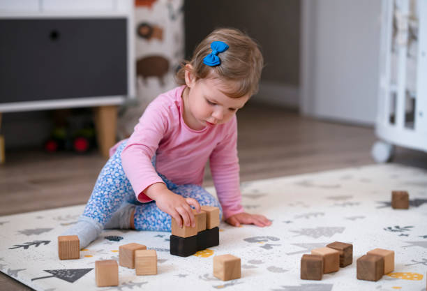 istock Child playing with blocks on the floor stock photo 1299405497